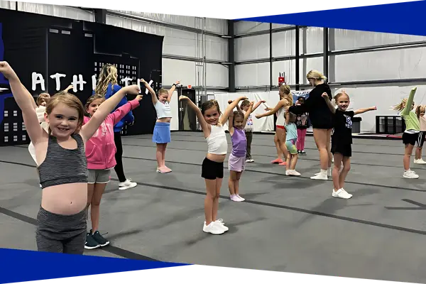 Young cheer students practicing arm motions together during class