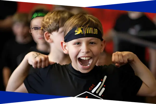 Excited young ninja athlete celebrating with teammates after a class